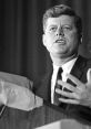 John F. Kennedy delivering a speech, showcasing his charismatic oratory and leadership style. Historical black-and-white photo.