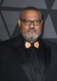 Laurence Fishburne at a red carpet event, showcasing a stylish black tuxedo and distinctive bow tie.