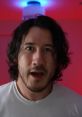 Markiplier with tousled hair and excited expression, set against a vibrant red and blue background.