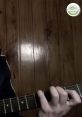 Hand playing guitar against wooden backdrop, showcasing a creative moment in Masi Rodríguez's musical journey.