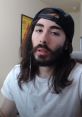 Moistcr1tikal in casual attire, wearing a cap, with long hair and a beard, captured during a gaming session.