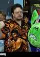 Roger L. Jackson, known as Mojo Jojo, poses with a vibrant shirt featuring martial arts imagery at a public event.