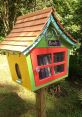 Colorful little library box filled with books, promoting community reading and access to literature in a serene outdoor setting.