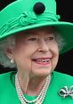 Queen Elizabeth II smiles gracefully, showcasing her iconic green outfit and elegant pearls at a public event.