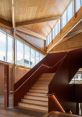 Modern interior of Tazmania Library featuring a wooden staircase and large windows, showcasing natural light and design elegance.