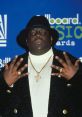 The Notorious B.I.G. at the Billboard Music Awards, showcasing his iconic style and gold jewelry.