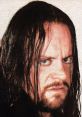 The Undertaker, iconic WWE wrestler Mark Calaway, showcases his intense expression and signature long hair.