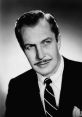 Vincent Price exudes charisma in a classic black-and-white portrait, tailored suit and distinctive mustache enhancing his charm.