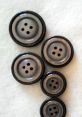 Black and gray buttons of varying sizes arranged neatly, perfect for crafting, sewing, or fashion projects.