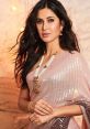 Katrina Kaif radiates elegance in a shimmering pink saree, showcasing stunning jewelry and graceful style in this captivating look.