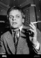 Klaus Kinski passionately gestures while holding a cigarette, embodying his intense persona as an enfant terrible of cinema.