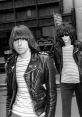 Ramones members in stylish leather jackets walking down city streets, embodying punk rock culture and carefree attitude.