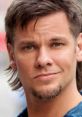 Theo Von sports a casual look with a charming smile, showcasing his signature hairstyle and engaging personality.