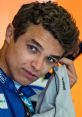 Lando Norris preparing for a race, showcasing his McLaren racing gear with a focused expression and distinct hairstyle.