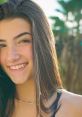 Smiling young woman with long hair in natural light, showcasing a confident and cheerful demeanor, ideal for social media.