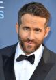 Ryan Reynolds in a classic tuxedo with a bowtie, showcasing his charming smile and stylish look at a red carpet event.