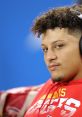 Patrick Mahomes in a red Kansas City Chiefs hoodie, showcasing his signature style and concentration before a game.