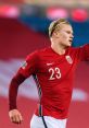 Erling Haaland celebrating a goal in Norway's red jersey, showcasing his passion and skill on the football field.