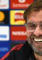 Jurgen Klopp smiling during a press conference, showcasing his charismatic personality and leadership in football.