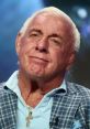 Ric Flair, legendary wrestler, smiles during an interview, showcasing his iconic style and charismatic personality.