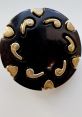 Vintage black button with gold heart-shaped accents, ideal for Guzich-inspired crafts or fashion accessories.