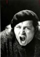 Sam Kinison passionately expressing his comedic style, wearing a beret and a striking outfit, capturing his iconic energy.