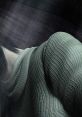 Close-up of a character from Silent Hill 2, featuring textured fabric and an atmospheric, eerie background.