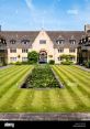 Beautiful courtyard of Nuffield College, featuring manicured lawns and a tranquil lily pond under a clear blue sky.