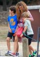 Mother and two children enjoying a carefree moment outdoors, reflecting family love and connection in a relaxed setting.