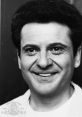 Classic portrait of Joe Pesci, showcasing his charismatic smile and iconic hairstyle, reflecting his legendary acting career.