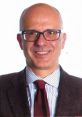 Professional portrait of Roke Julio Garcia Monsalve, smiling, wearing glasses, with a striped shirt and a tie.