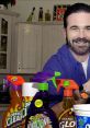 Billy Mays promotes various cleaning products on a kitchen counter, showcasing the New Version of his signature sales style.