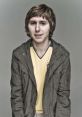 Jay Cartwright from *The Inbetweeners*, wearing a yellow jersey and gray jacket, showcasing his distinct style.