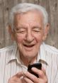 Smiling elderly man holding a smartphone, enjoying conversation and ready to annoy spam callers with "Hello this is Lenny.