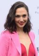 Gal in a stylish pink blazer and red top, smiling confidently at a public event, showcasing her beauty and charm.