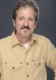 Terry Thompson smiling in a casual beige shirt, showcasing a friendly demeanor against a neutral background.