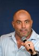 Joe Rogan passionately engages with the audience while holding a microphone, showcasing his dynamic personality.