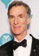 Bill Nye smiling at the Shorty Awards, wearing a stylish bow tie and a black suit, promoting science education and innovation.