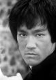 Black and white portrait of Bruce Lee showcasing his intense gaze and iconic hairstyle, reflecting his martial arts legacy.