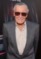 Stan Lee smiles in sunglasses at a comic event, embodying his legacy as a legendary comic book creator and cultural icon.