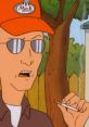 Dale Gribble, wearing sunglasses and a cap, smokes while expressing his conspiracy theories outdoors.