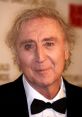 Gene Wilder at a red carpet event, showcasing his iconic smile and unique style in classic formal attire.