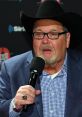 Jim Ross speaking passionately into a microphone, wearing a cowboy hat and a blue blazer, showcasing his iconic wrestling persona.