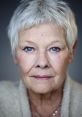 Close-up portrait of Judi Dench showcasing her striking blue eyes and distinctive short hairstyle, exuding timeless elegance.