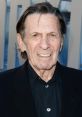 Leonard Nimoy smiles while wearing a black suit at a public event, showcasing his iconic presence in entertainment history.