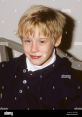 Young Macaulay Culkin smiles warmly, showcasing his iconic look from 1990-1994, the era of his childhood film stardom.