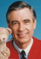 Fred Rogers smiles warmly while holding a puppet, showcasing his friendly demeanor and connection with children.