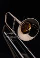 Shiny brass trombone with a reflective surface, showcasing its elegant design against a black background.