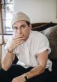 Jeremiah Culberson in a white shirt and knit beanie, seated thoughtfully in a cozy indoor setting.