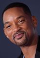 Will Smith smiling confidently at a red carpet event, showcasing his signature style and charismatic presence.